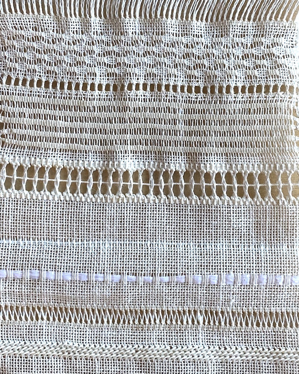 Tracy A Franklin, Whitework Sampler, 2023. Approximately 10cm x 30.5cm (4” x 12”). Pulled work, drawn thread work, surface stitching, weaving. Plain weave fabric, a variety of threads, and paper ribbon.