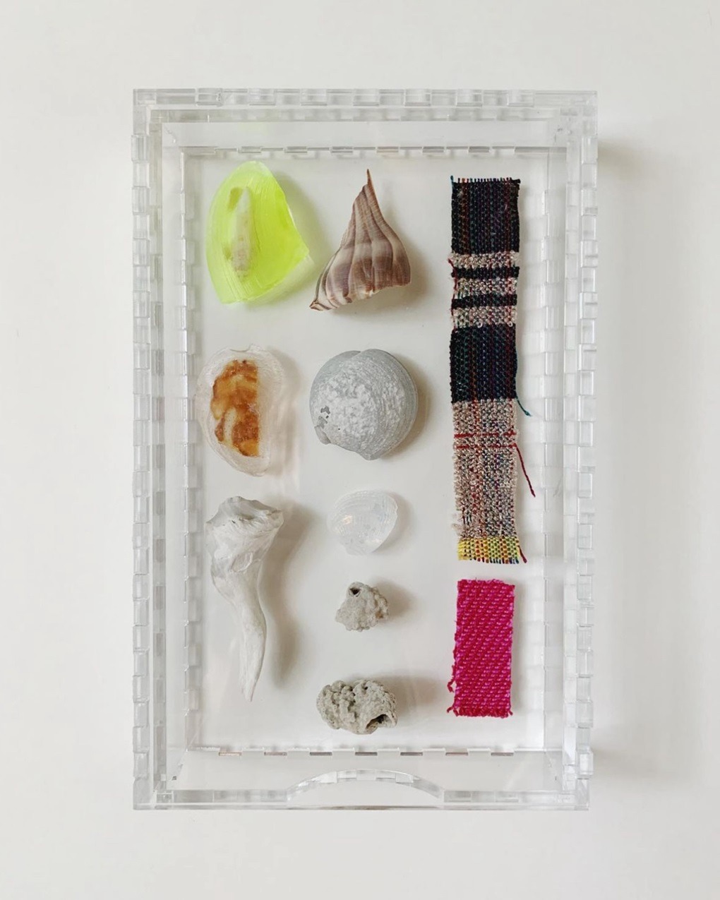 Amanda Britton, Carapace Capsules, 2023. 33cm x 33cm (13" x 13"). Weaving, resin casting, laser cutting. Plexiglass, resin, shells and Johanna Norry’s woven remnants.