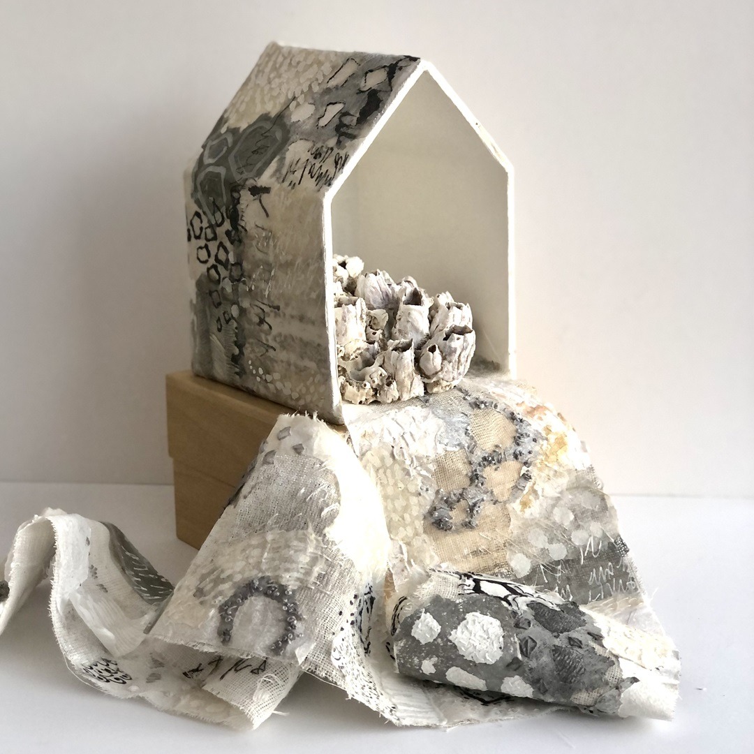 Rachael Singleton, Barnacle House, 2019. House: 10cm x 15cm (4" x 6"). Fabric: 1m x 9cm (40" x 4"). Hand stitch, collage, distressing. Wet-strength papers, natural fabrics, encaustic wax medium, grey-board.