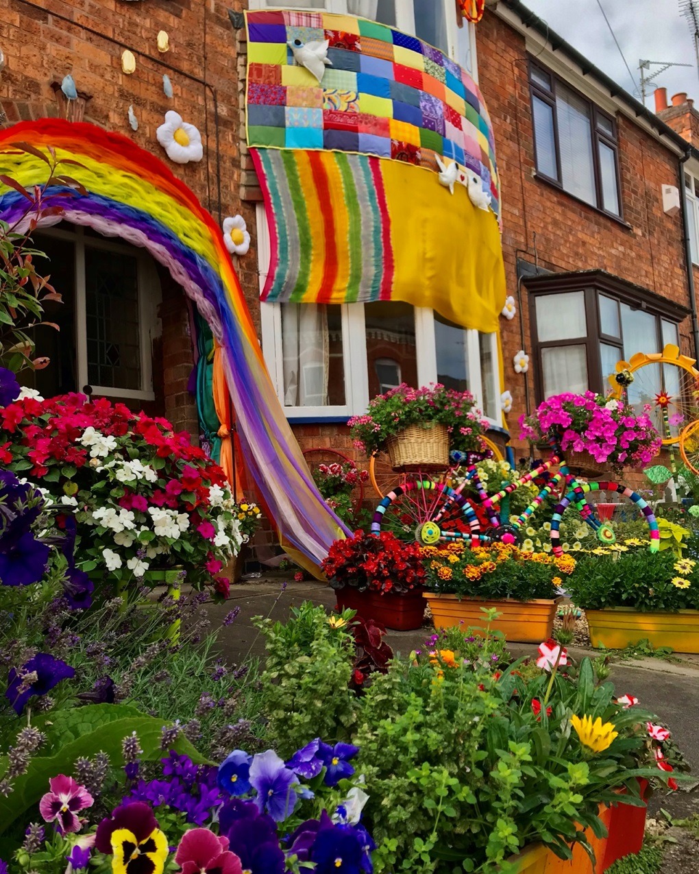 Alison Carpenter-Hughes, Blooming Lovely, 2021. Size unknown. Patchwork, weaving, wrapping, sewing, soft sculpture. Mixed media including repurposed objects and real flowers.