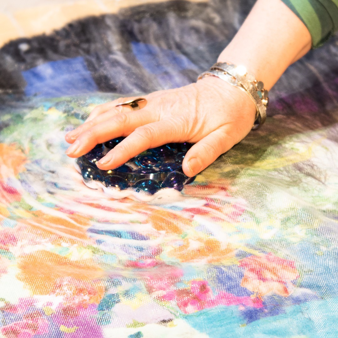 Using soap and hot water to felt the merino tops by hand into a textile composition.