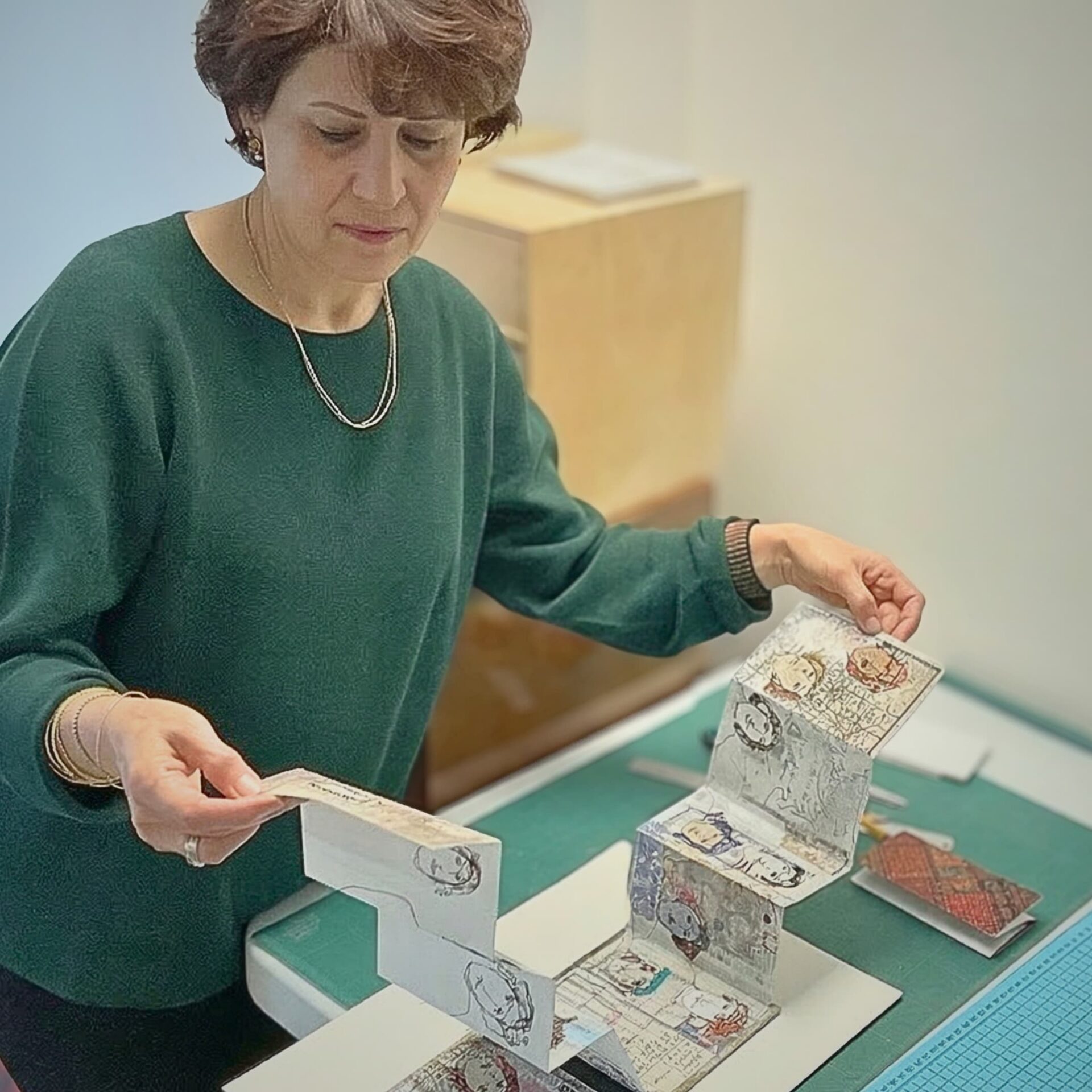 Artist examining intricate handmade book