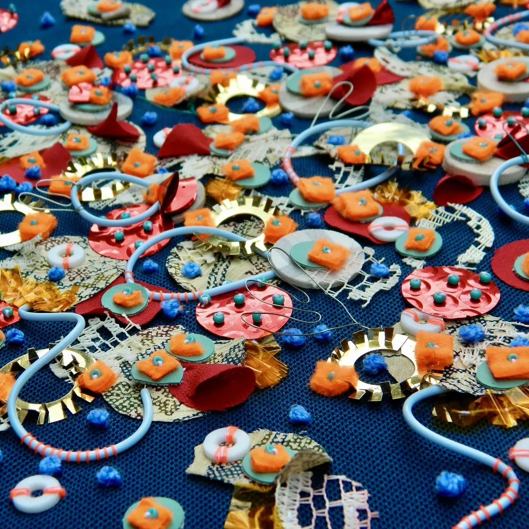 Jessica Grady, Scattered (detail), 2021. 40cm x 80cm (15 ¾" x 31½"). Vintage silk kimono, painted lace, waste sequin film, tubing, neon thread, florist cellophane, wire and plumbing offcuts stitched on deadstock fabric.