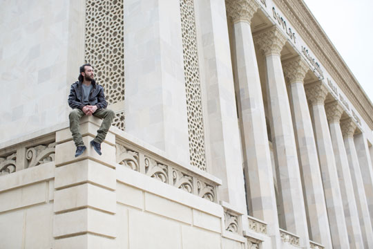 Artist Faig Ahmed sits on a building in Baku