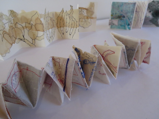 San Diego Book Arts 2: More folding exercises. The piece by Altheas Brimm at rear of picture demonstrates the drawing being followed as a line through the piece.