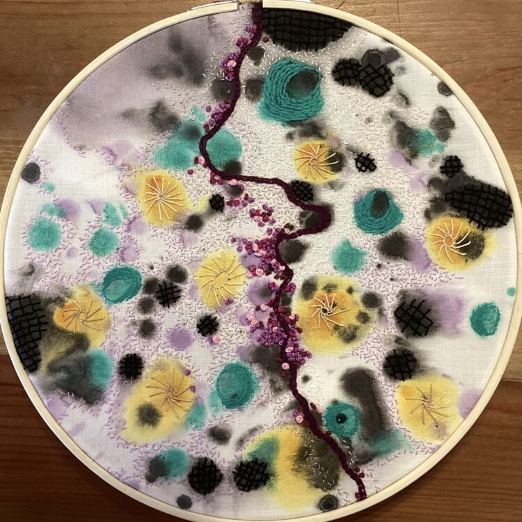 Grace Megnet, Taking a Point For a Walk, inspired by Paul Klee, 2023. 15cm (6") diameter. Painting, hand embroidery including back stitch, seed stitch, buttonhole stitch, stem stitch, french knots, trellis stitch. Acrylic paint, wool thread, stranded cotton embroidery threads, antique linen napkin.