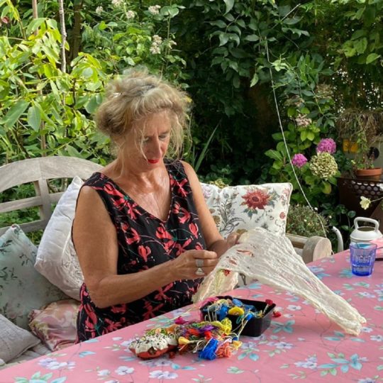 Mathilde Renes stitching at her garden table. Photo: Onno van den Brink