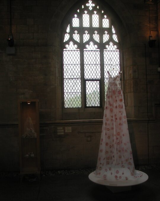 Jennifer Collier, Strawberry Wedding Dress, with Veil and Bouquet. Commission for 20-21 Visual Arts, Scunthorpe. A strawberry wedding dress, with accessories for the 'Food, Glorious Food' exhibition, 2004. 150cm x 150cm (59" x 59"). The strawberry slices were 'baked' between layers of organza, and then cut and machine-stitched to form the dress. The bodice was embroidered with jelly tots between layers of organza, and the train had pink jelly beans hand stitched into the hem all the way around. Organza, strawberry slices, jelly tots, jelly beans, hand and machine stitch.