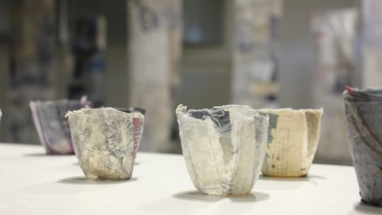 Cas Holmes, Empty Vessels, 2022. 80 pieces: each 9cm x 6cm x 6cm (4" x 2" x 2"). Layered and bonded collage, printed, dyed, machine and hand stitch. Paper and lace. Photo: Cas Holmes.