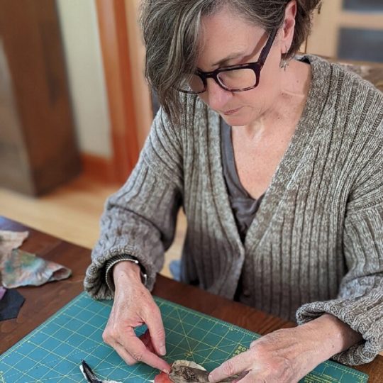 Ann Smith, laying out a group of birds at the dining room table.