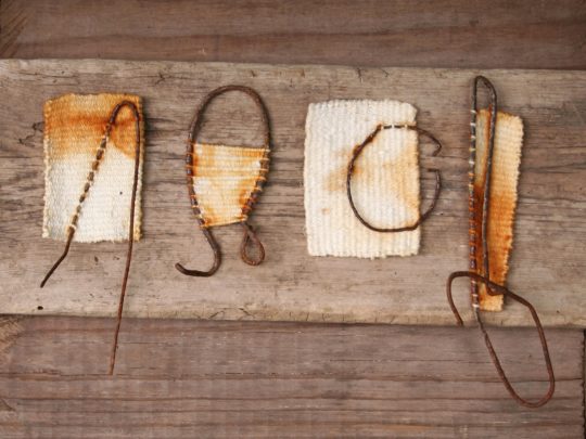 Alice Fox, Tide Line (group) (detail), 2013. Individual units vary from 2cm to 20cm (¾" x 8"). Tapestry weave, rust staining. Found rusty objects, cotton.