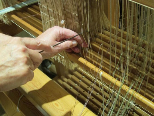 Threading the heddles on the loom