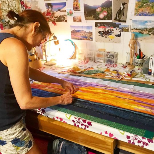Jackie working in her former home studio, guided by her extensive mood board.