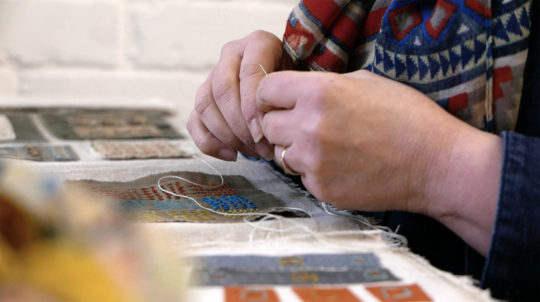 Sue Stone working on her stitched samples