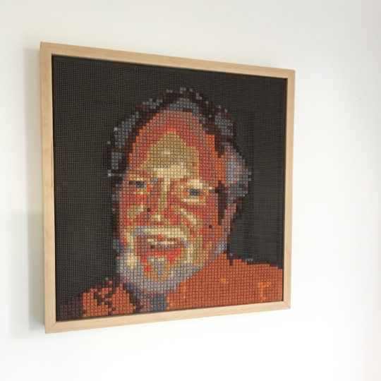 Zoe Gilbertson: My Dad at 70, 2016, oak frame, tapestry canvas, spray paint, tapestry wool using a made up stitch to create a pixel effect.