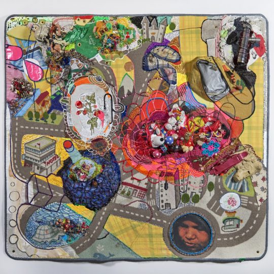 Julie Peppito, Crawling on Cancer (The Teflon Toxin by Sharon Lerner), 2016. 132cm x 138cm x 15cm (52" x 55" x 6"). Carpet, trim, photo, thread, found objects, fabric paint, fabric, grommets. Photo: Dan Gottesman