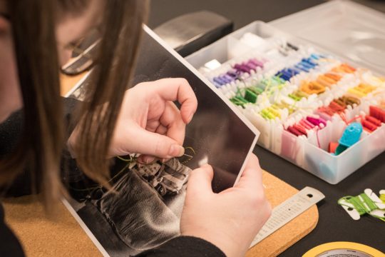 Liz Jeary stitching into a print