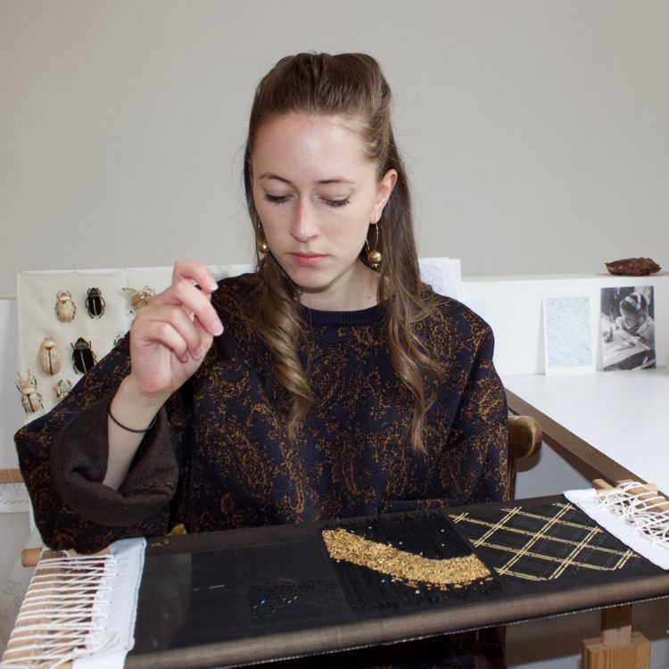 Claire de Waard in her home studio, working on a straw embroidery sample for interiors.