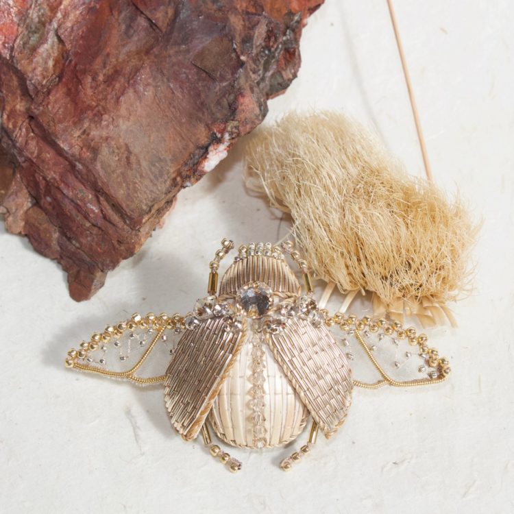 Claire de Waard, Straw Embroidered Beetle Brooch, 2022. 5.5cm x 6.5cm (2¼" x 2½"). Straw embroidery, goldwork, stumpwork, beading. Organza, straw, goldwork threads, straw thread, seed beads, padding, crystal sew-on.