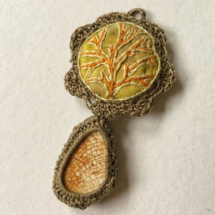 Mirjam Gielen, Pendant, 2020. 7cm x 3cm (2½" x 1"). Eco dyeing, embroidery, crochet. Eco printed silk, embroidery threads, crochet threads, antique pottery shard.