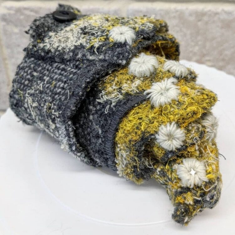 Nerissa Cargill Thompson, Shell, 2020. 21cm x 10cm x 17cm (8¼" x 4" x 6½") including plinth. Embellished and embroidered recycled fabrics with button detail.