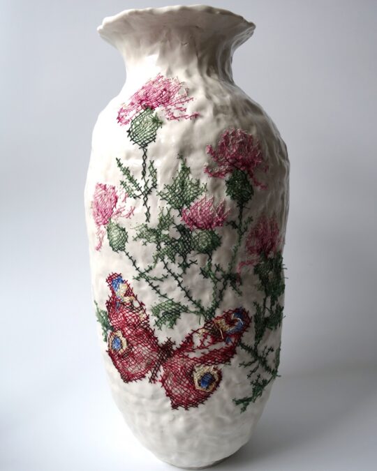 Caroline Harrius, Cross Stitched Vase with Butterfly, 2021. 42cm tall (16½“). Coiled porcelain, decorated with cotton thread, pattern from a DIY kit. Porcelain, cotton thread.