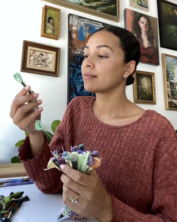 Cassandra Dias choosing from her thread colour selection in her home workspace
