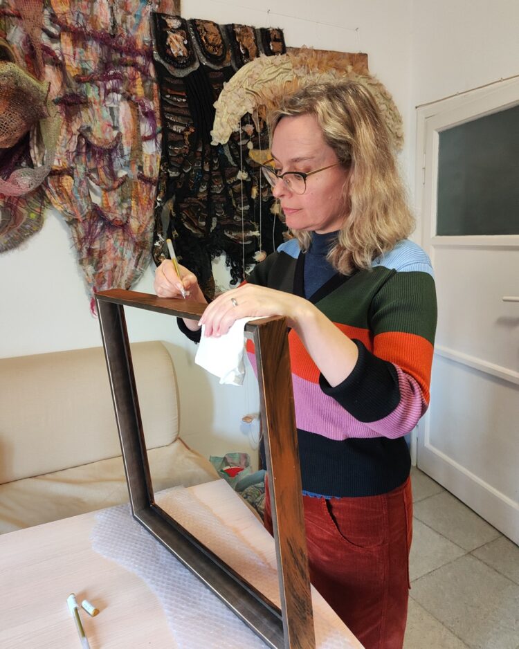 Olga Teksheva hand painting a frame in her previous studio in Rome.