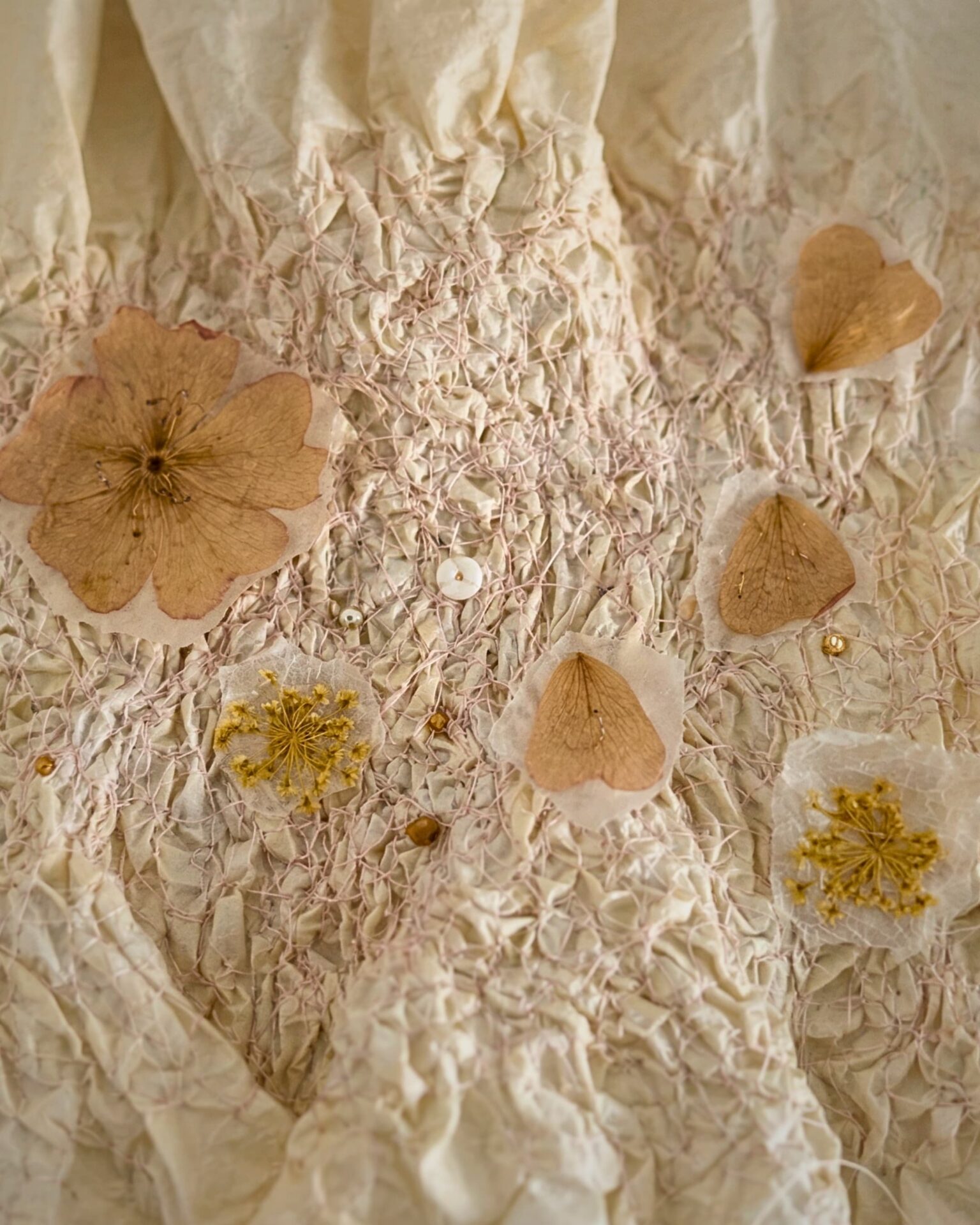 Delicate fabric adorned with pressed flowers.