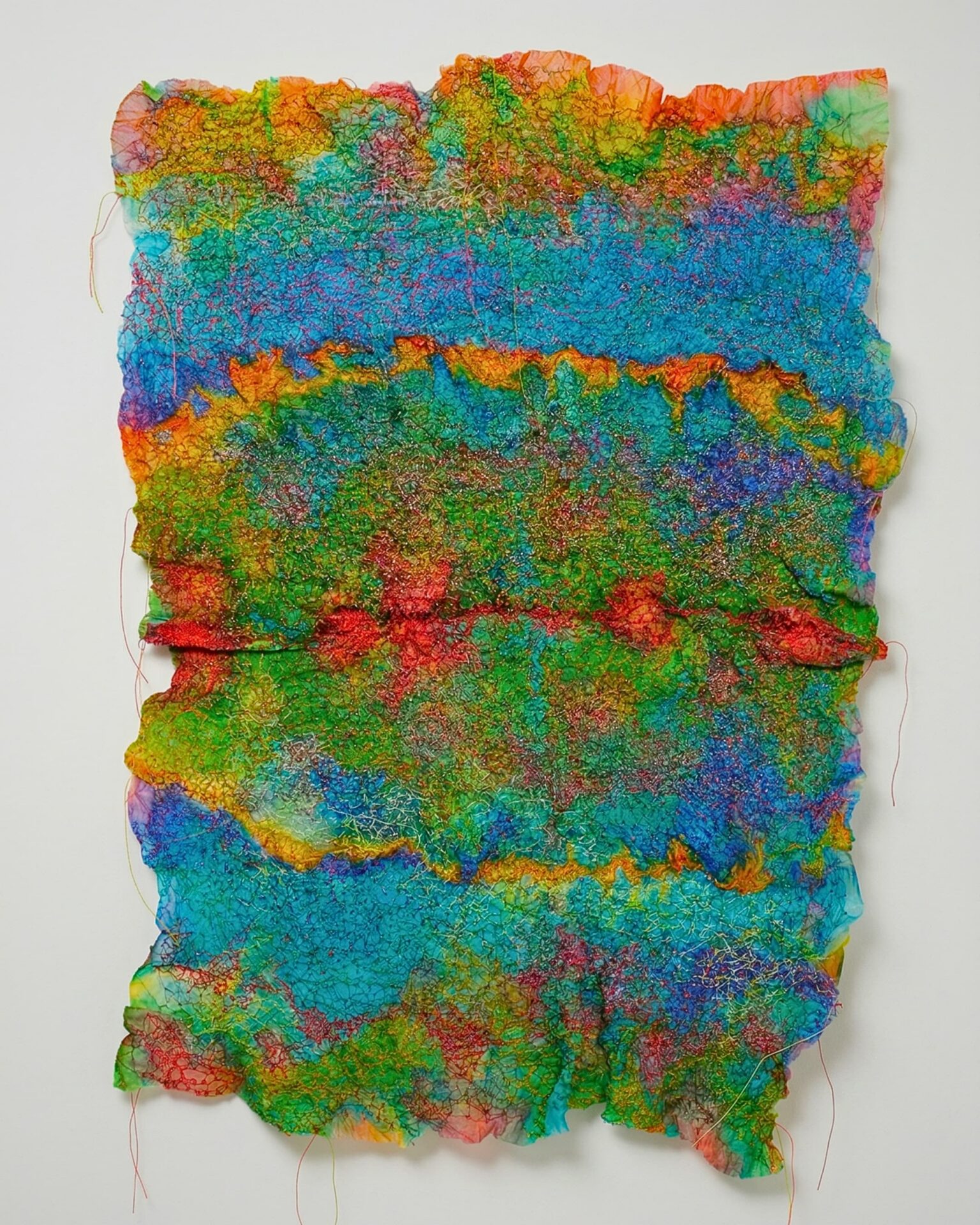 Vibrant, textured abstract fabric artwork.