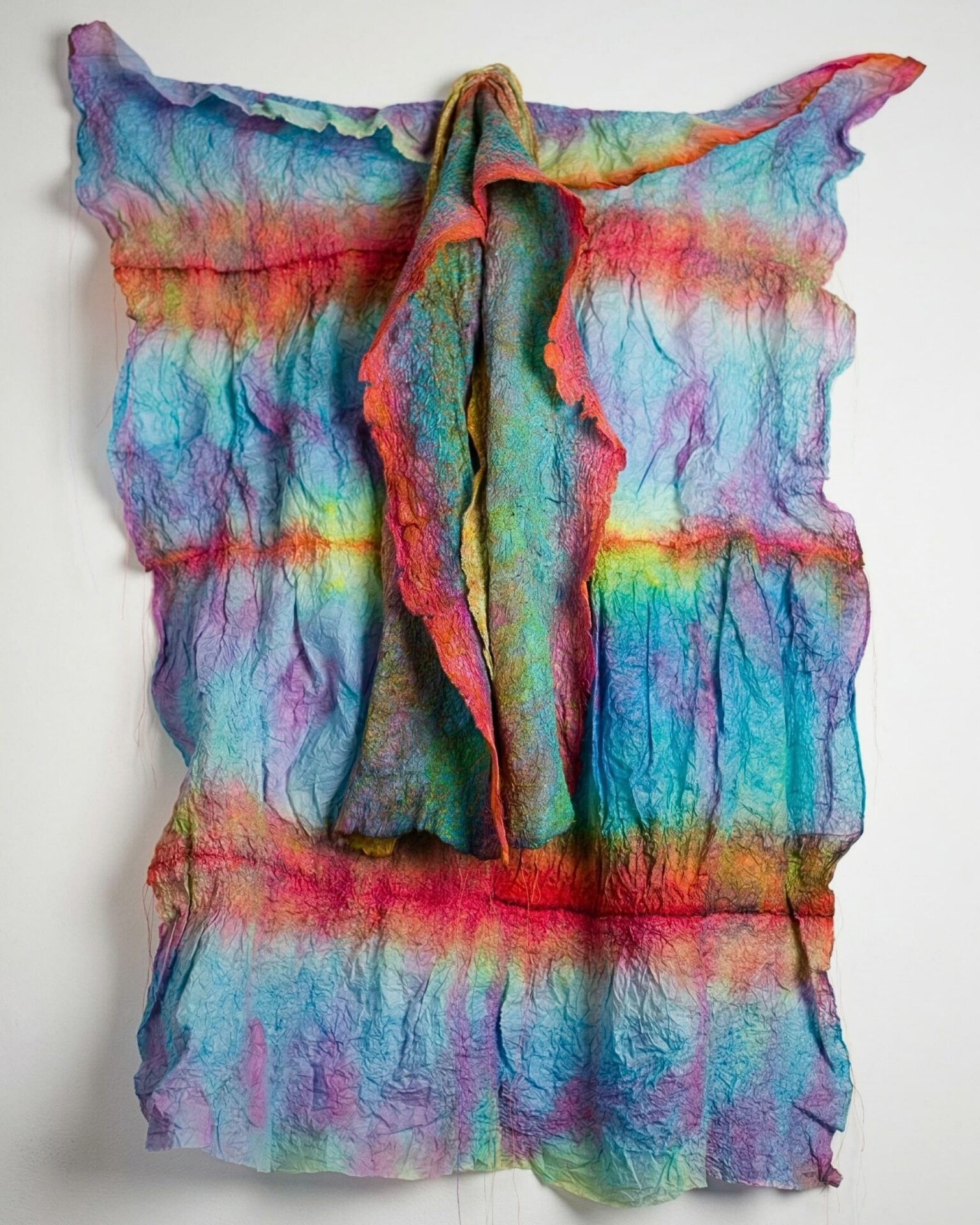 Vibrant, textured fabric dress artwork hanging.
