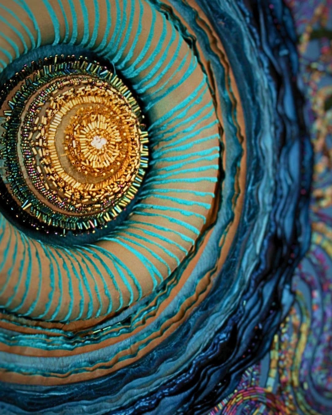 A close up of an intricate circular textile artwork.