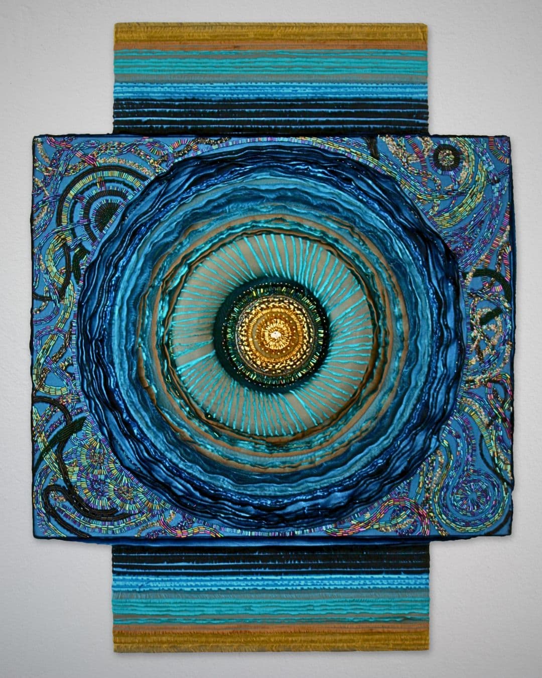 A mixed textile circular abstract artwork.