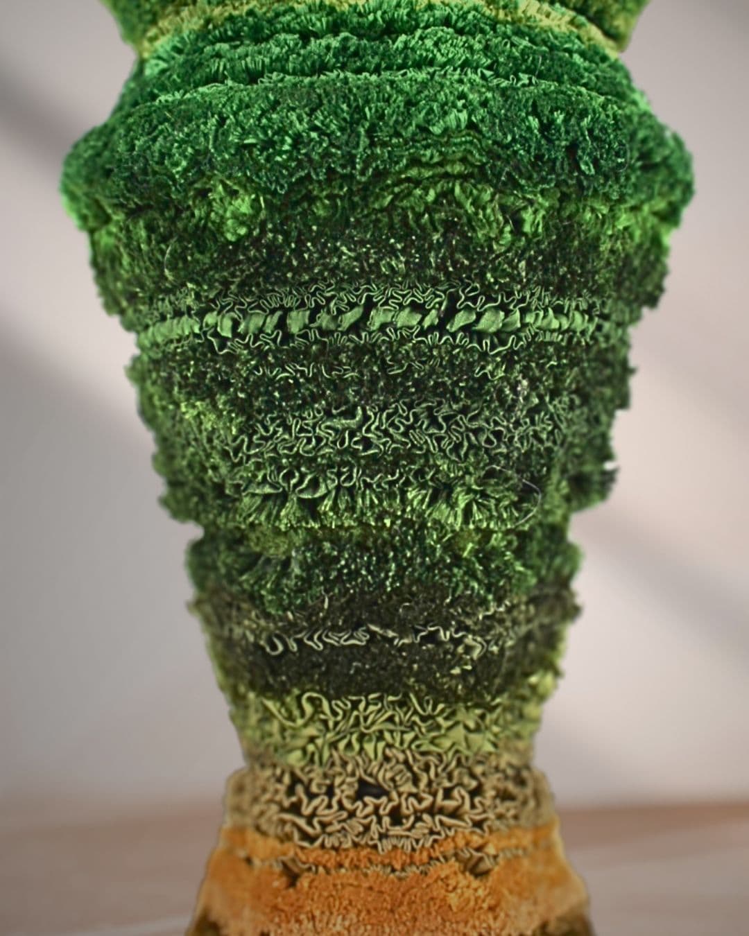 A textured green sculpture resembling natural forms