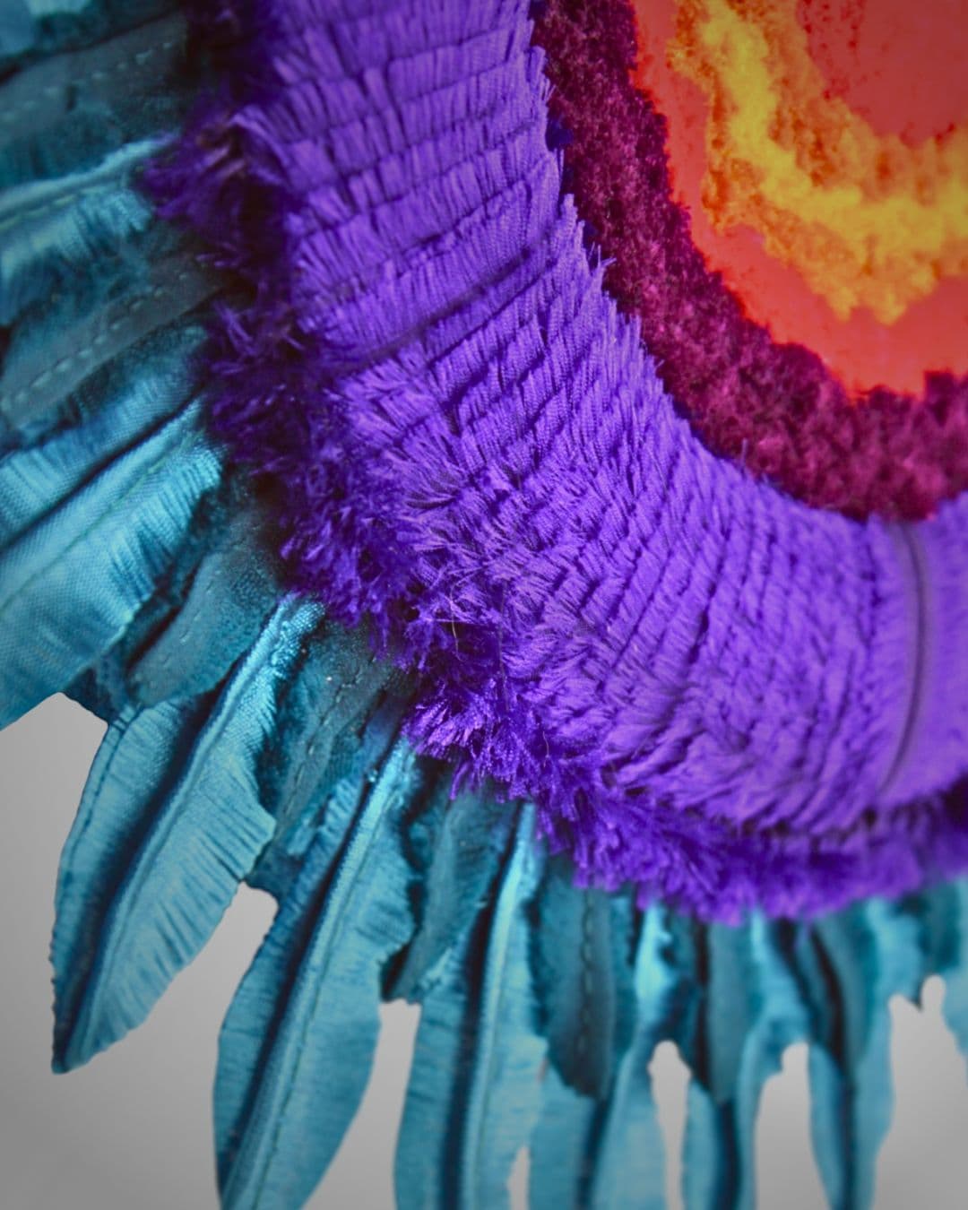 Close image of a vibrant circular textile artwork.