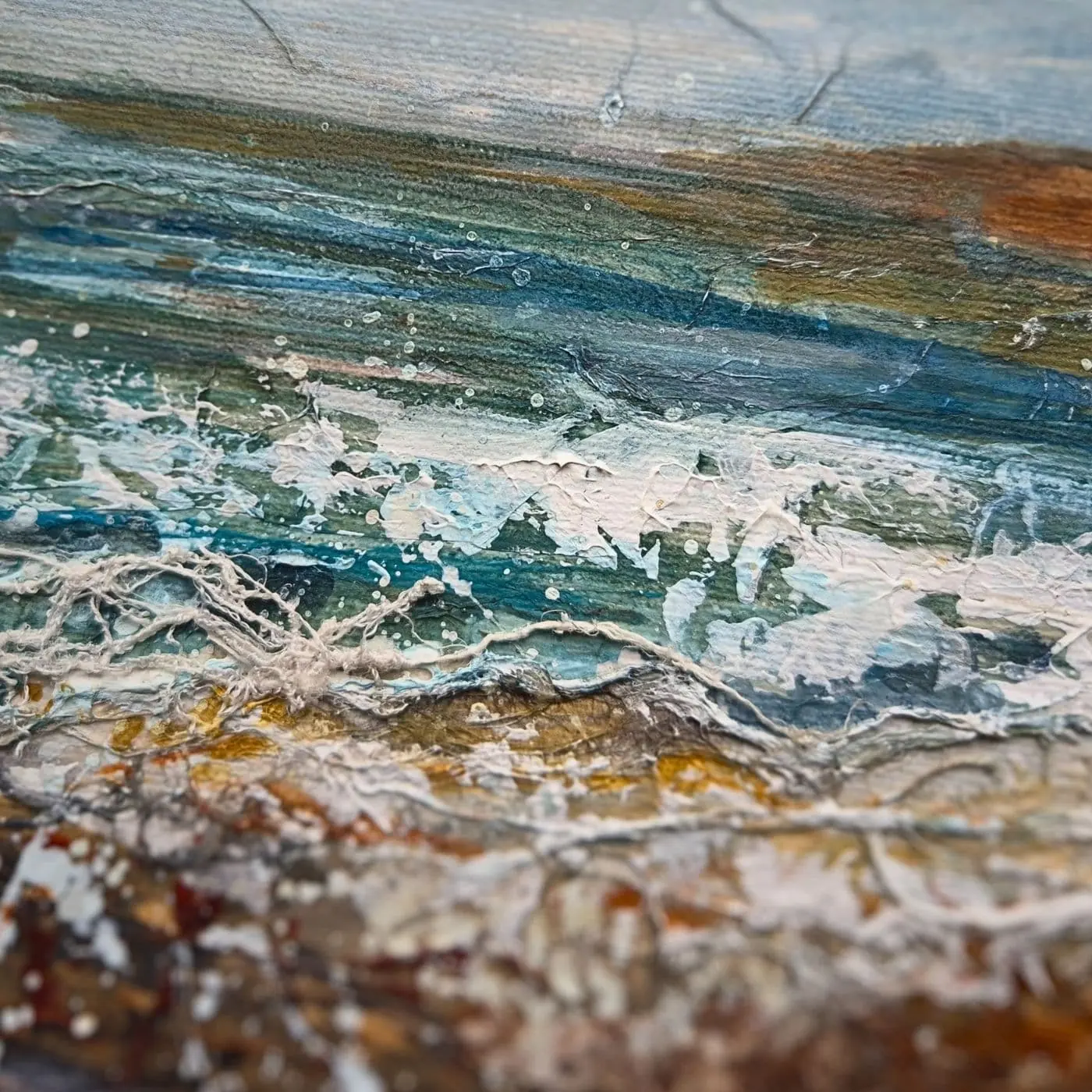 A close up of a painting of the sea with stitching