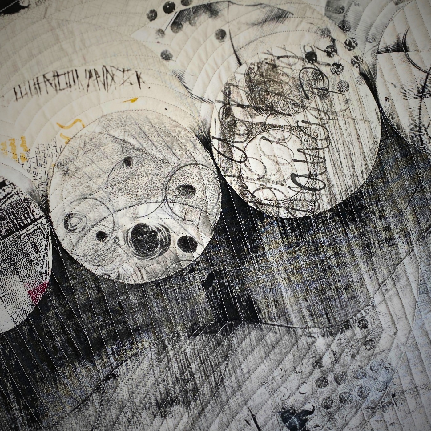 Black and white abstract circular patterns on textured fabric.