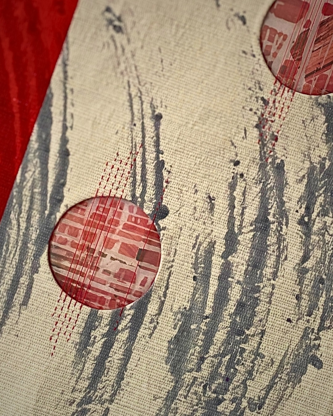Abstract textile art with circular cutouts.