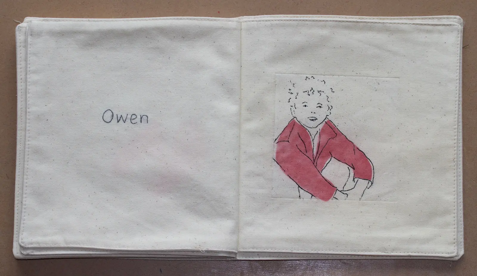 Andrea Cryer: etching - photograph of pages from the etched soft fabric book, showing my son and hand-stitching