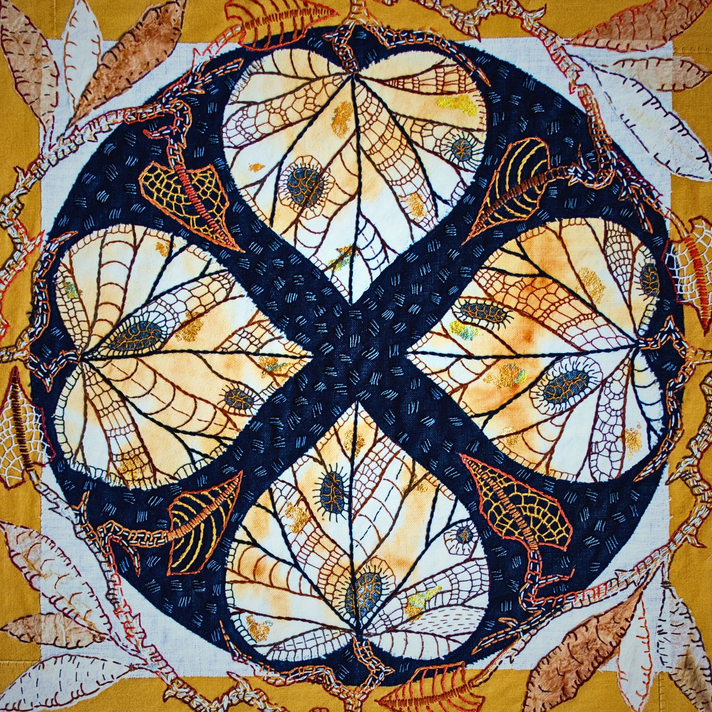 Intricate stitched pattern of leaves and insects.