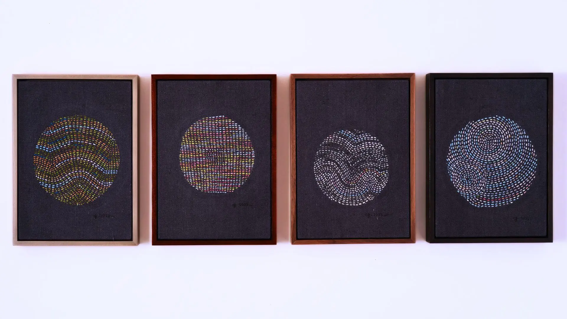 A group of framed hand stitched artworks depicting planets