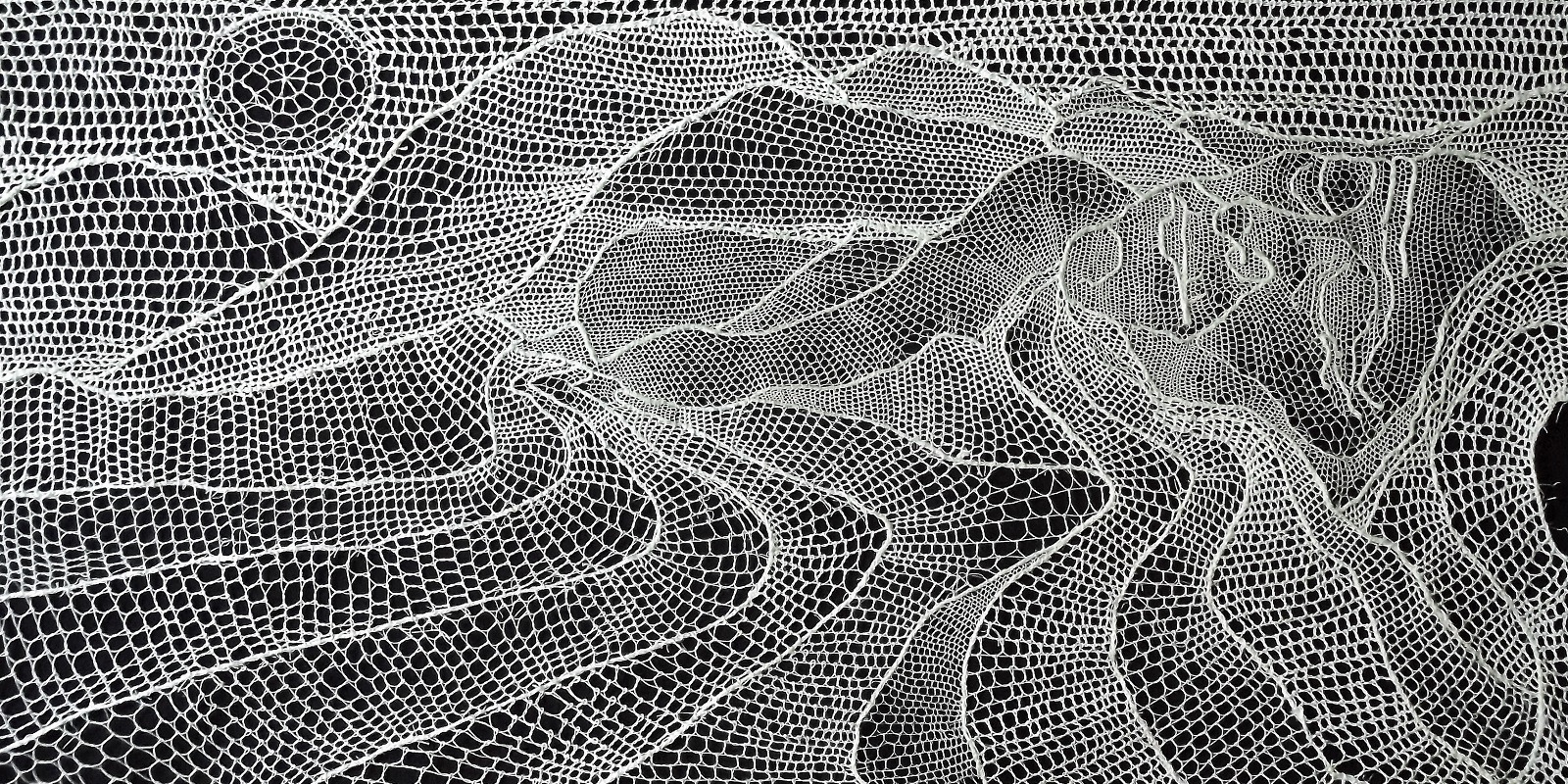 A thread piece of art using white thread to depict a lady in a landscape