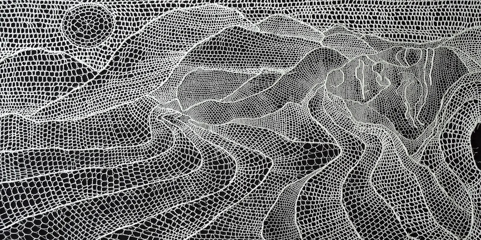 A thread piece of art using white thread to depict a lady in a landscape