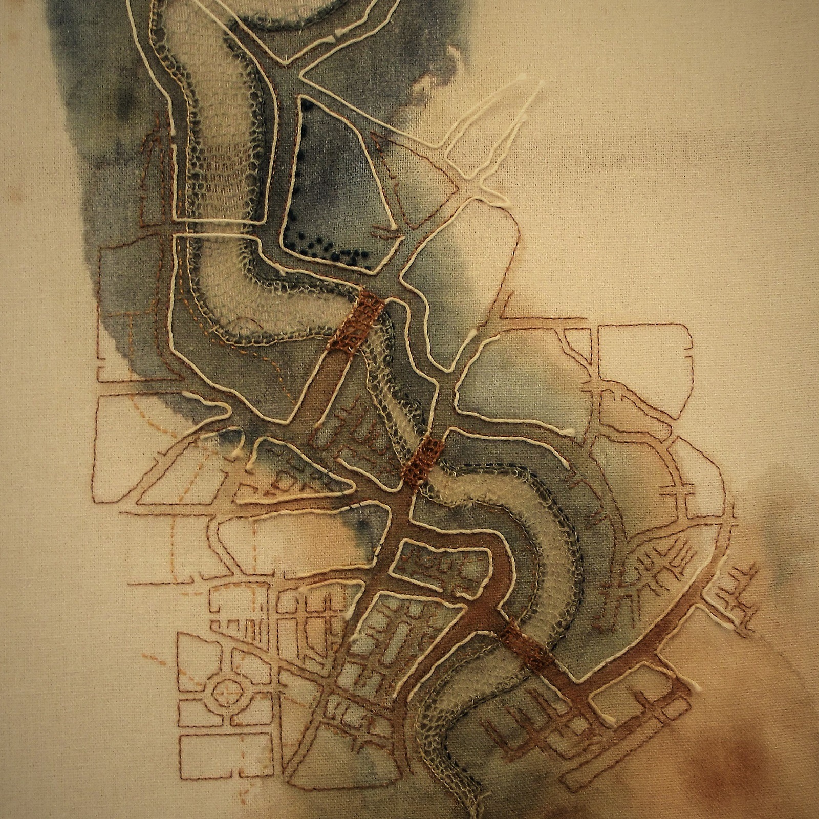 An embroidered map of a city and river