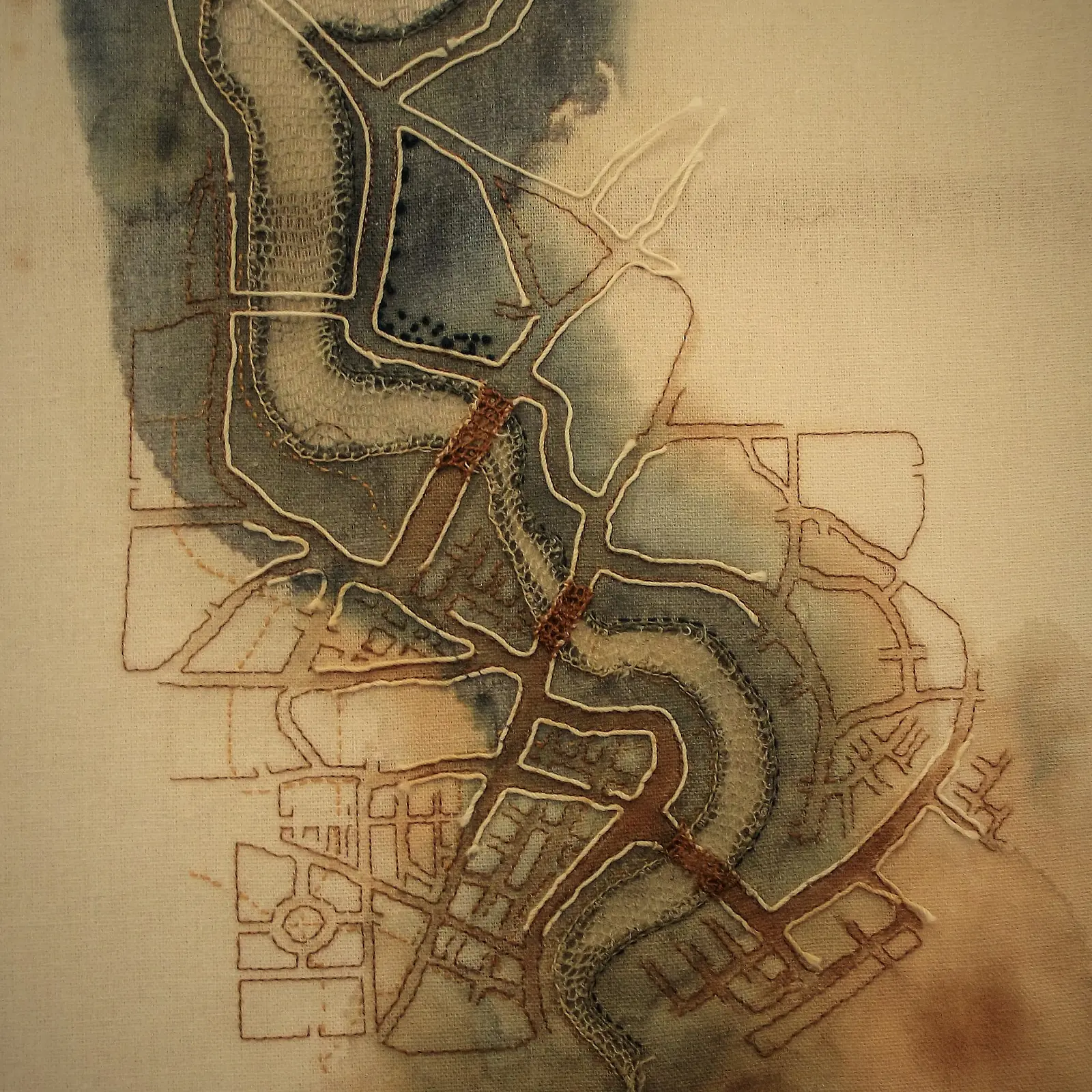 An embroidered map of a city and river