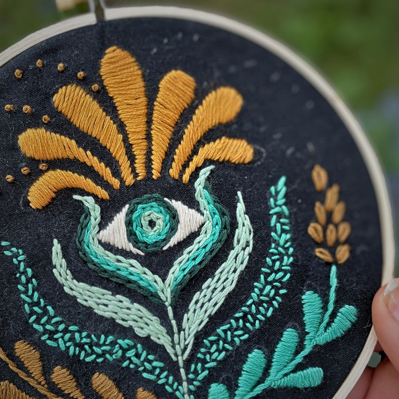 Embroidery hoop with stylized plant with an eye