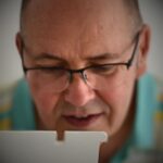 A close up image of textile artist Darren Ball working at his sewing machine.