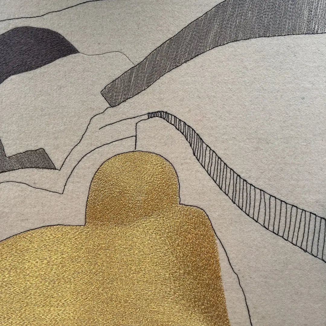 Abstract textile art piece featuring a wall and gold section