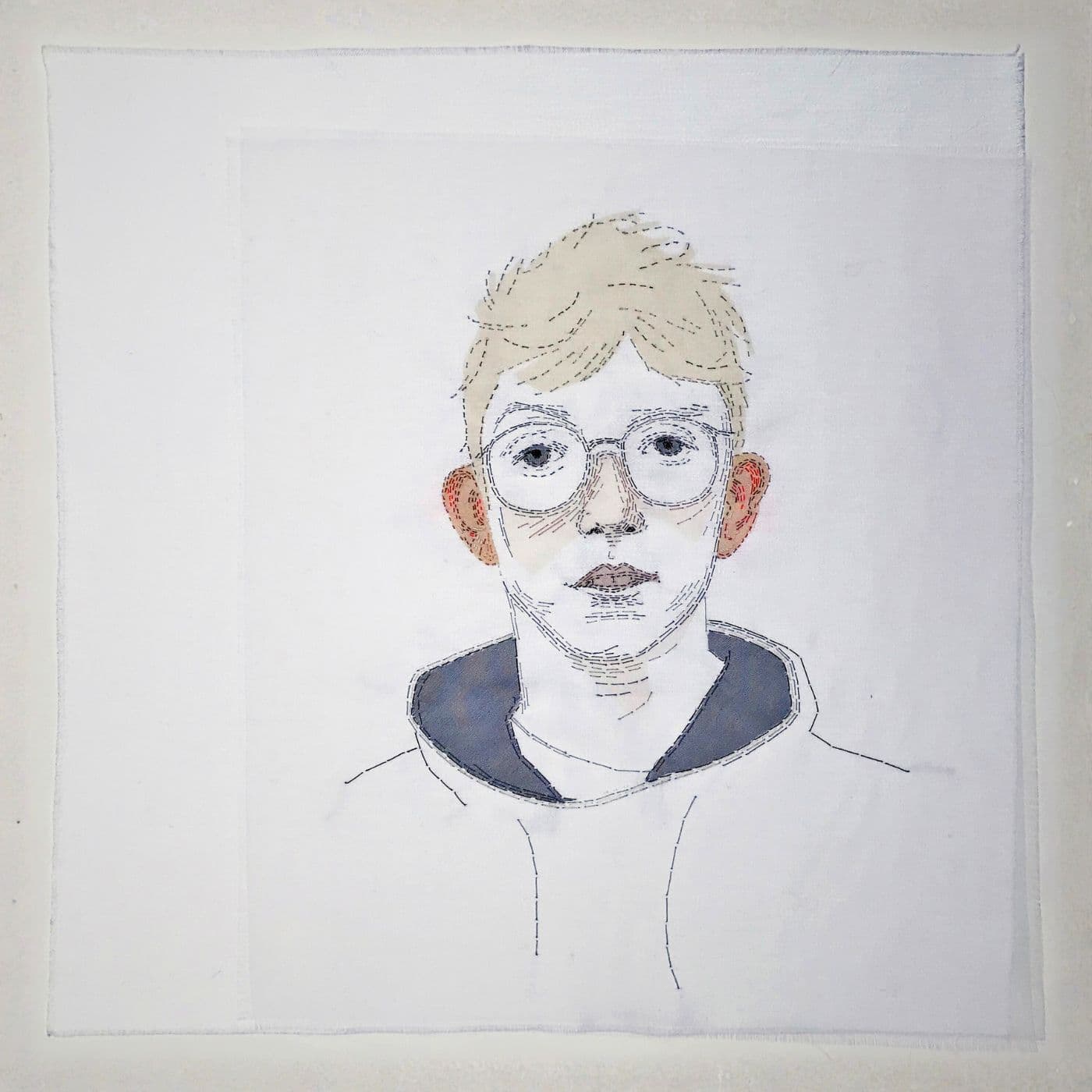 Textile artowkr of a boys face with glowing ears