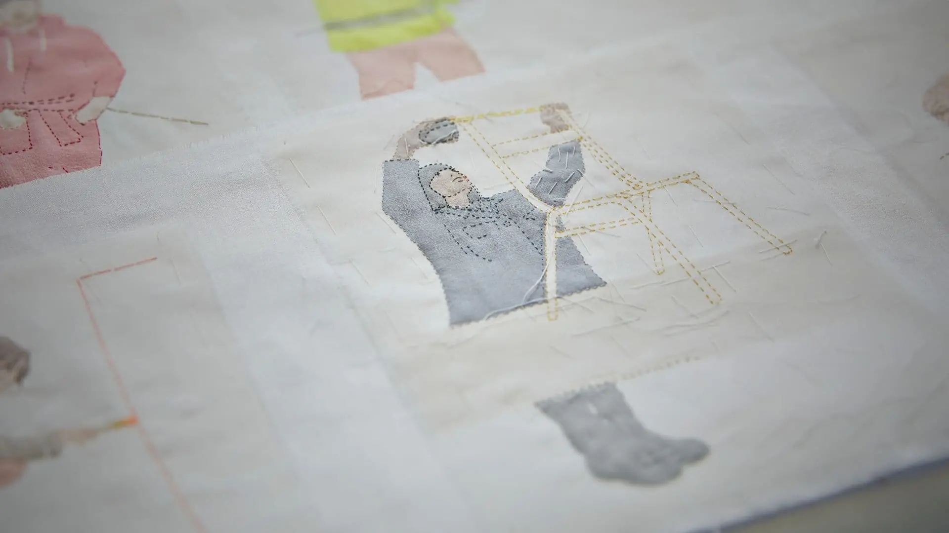 Stitched textile artwork of a propmaker at work.